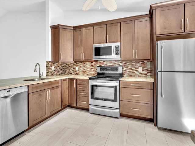 kitchen featuring stainless steel appliances, sink, lofted ceiling, and tasteful backsplash