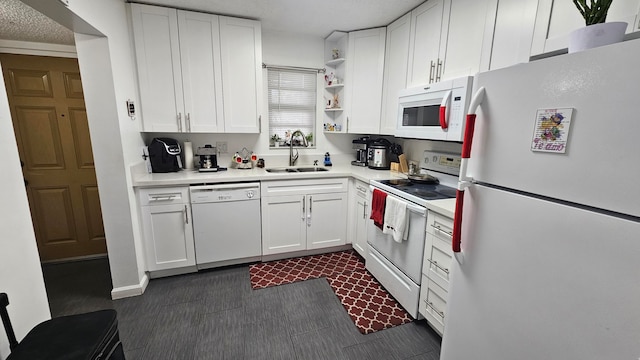 kitchen featuring a textured ceiling, white cabinetry, sink, and white appliances