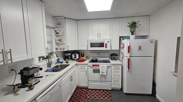 kitchen featuring a textured ceiling, sink, white cabinets, and white appliances