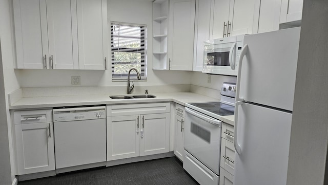 kitchen featuring white appliances, a sink, and white cabinets