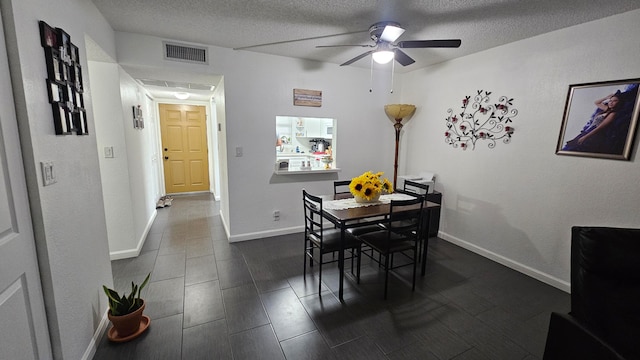 dining room featuring ceiling fan and a textured ceiling