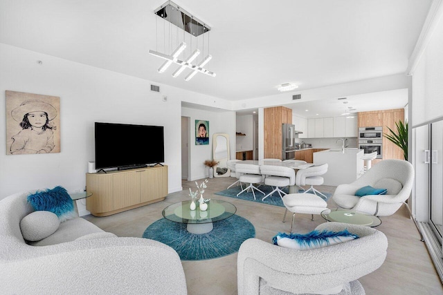 living room featuring sink and a notable chandelier