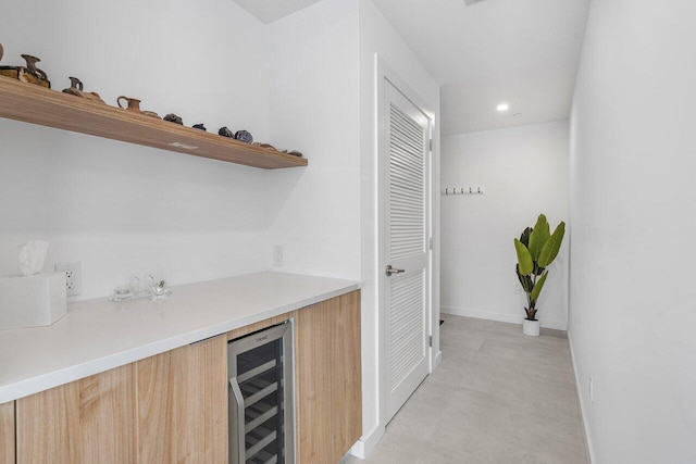 bar featuring beverage cooler and light brown cabinets