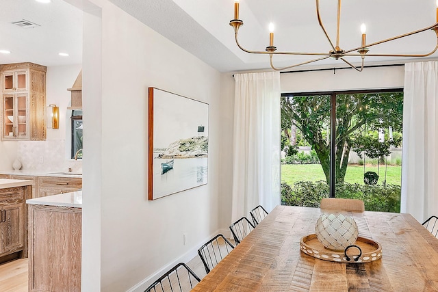 dining room featuring light hardwood / wood-style floors, an inviting chandelier, and sink