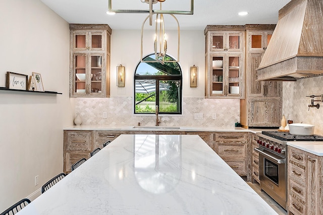 kitchen featuring custom range hood, sink, light stone counters, and premium stove