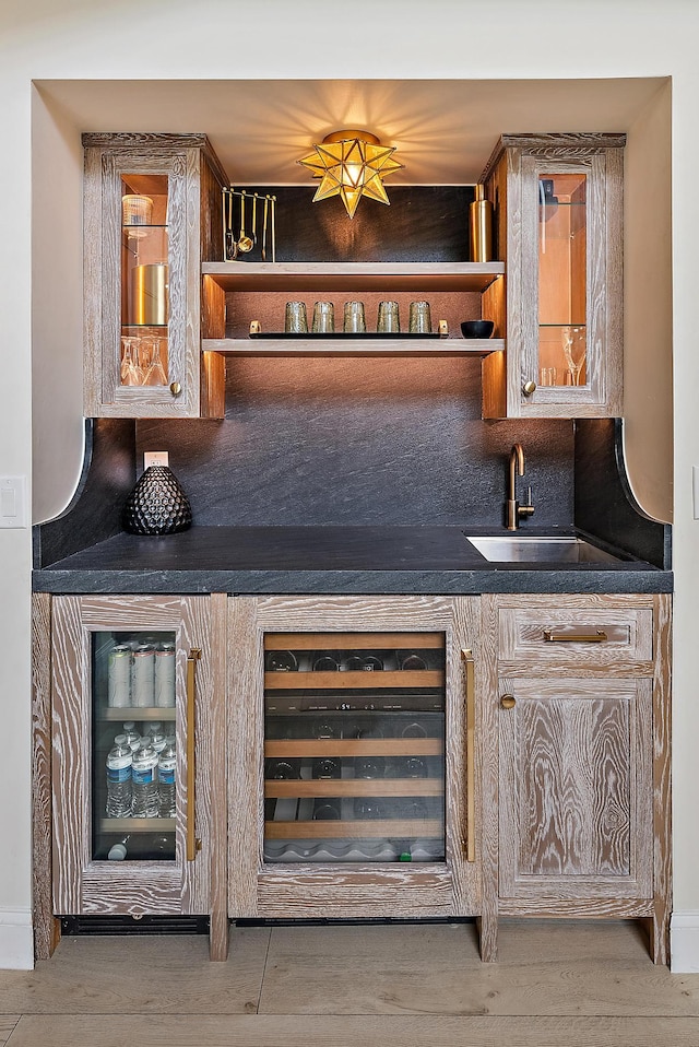 bar featuring decorative backsplash, wine cooler, and sink