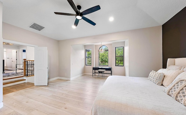 bedroom featuring ceiling fan, lofted ceiling, and light wood-type flooring