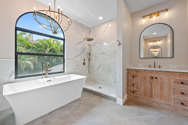 bathroom featuring vanity, a chandelier, independent shower and bath, and tile walls