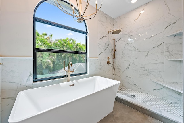 bathroom with a notable chandelier, shower with separate bathtub, and tile walls