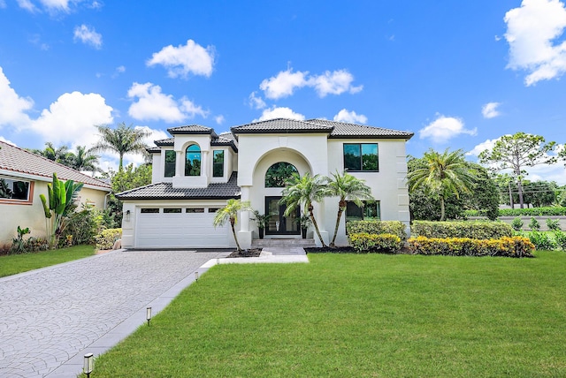 mediterranean / spanish house with a front lawn and a garage