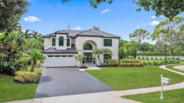 mediterranean / spanish-style home featuring a garage and a front lawn