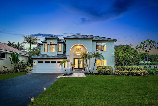 mediterranean / spanish-style home featuring a garage and a lawn