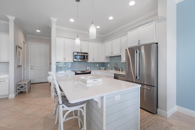 kitchen featuring white cabinets, crown molding, stainless steel appliances, and backsplash