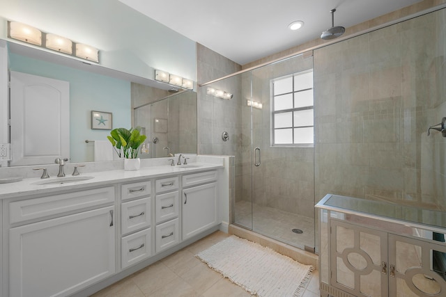 bathroom featuring double vanity, a sink, a shower stall, and tile patterned floors