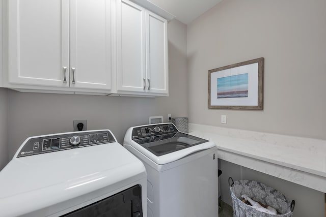 clothes washing area featuring cabinet space and independent washer and dryer