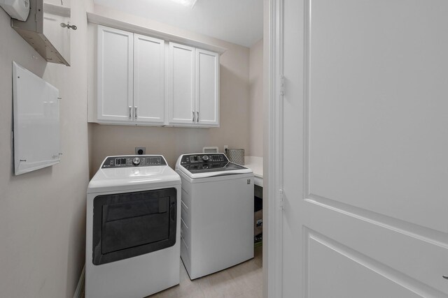 laundry area with cabinets and washing machine and dryer