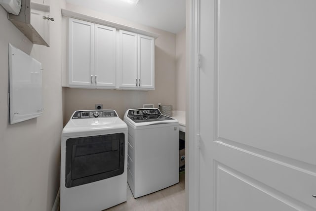 laundry room featuring cabinet space and separate washer and dryer