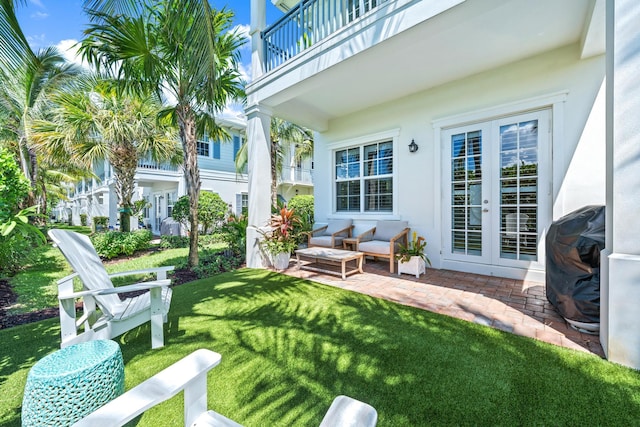 view of yard with a balcony, a patio, and french doors