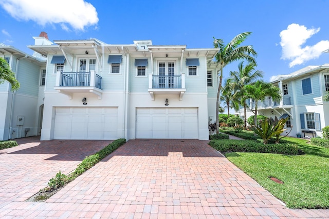 view of front of home featuring a garage, decorative driveway, and stucco siding