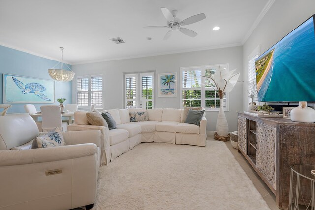 living room with ceiling fan with notable chandelier and ornamental molding