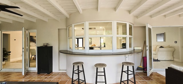 kitchen featuring wooden ceiling, tile patterned flooring, and a breakfast bar