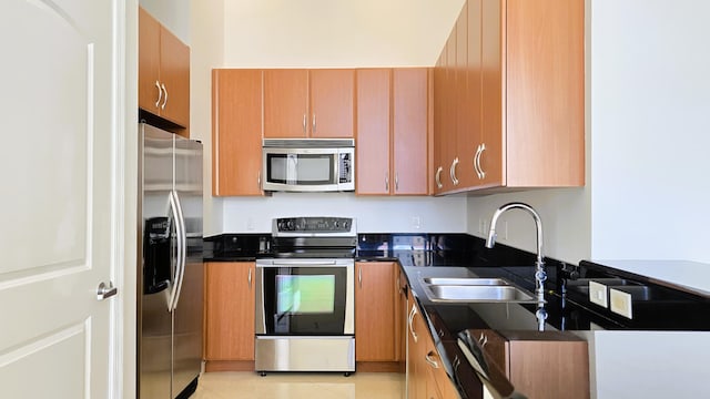 kitchen with light tile patterned flooring, appliances with stainless steel finishes, and sink