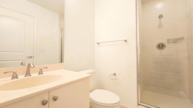 bathroom with vanity, a shower with shower door, and toilet