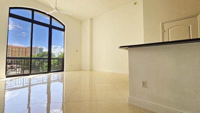 tiled empty room featuring ceiling fan