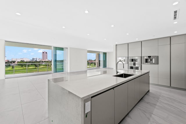 220 SE Mizner Blvd Unit 523, Boca Raton, FL 33432 - kitchen featuring a sink, gray cabinets, modern cabinets, a large island with sink, and recessed lighting