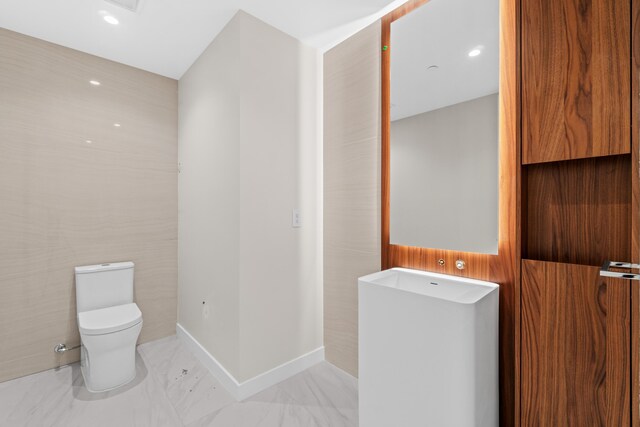 220 SE Mizner Blvd Unit 523, Boca Raton, FL 33432 - bathroom with marble look tiles, toilet, and recessed lighting