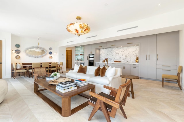 living room with a notable chandelier and sink