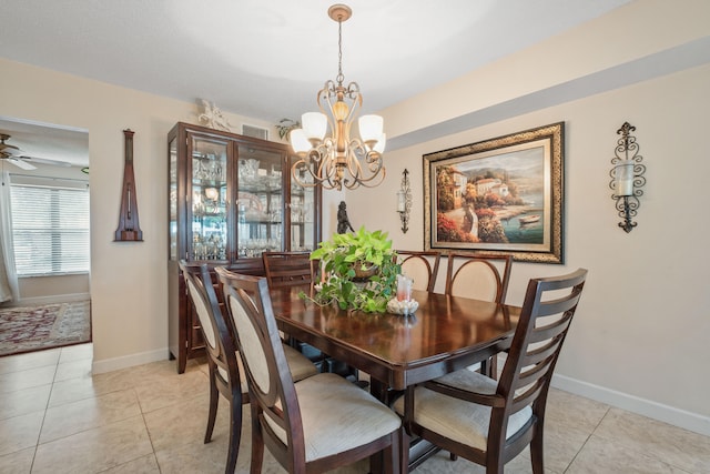 tiled dining area with ceiling fan with notable chandelier