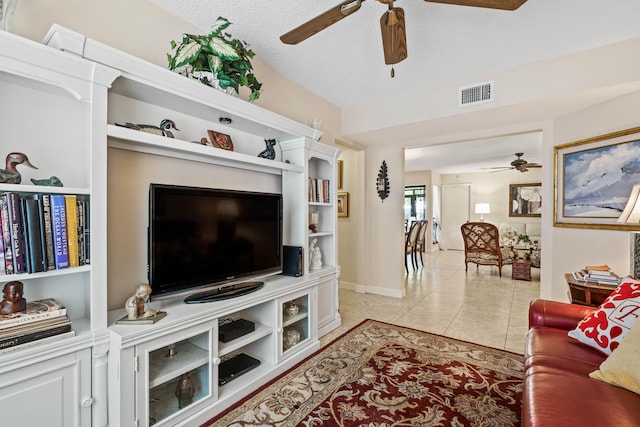 tiled living room with ceiling fan and a textured ceiling