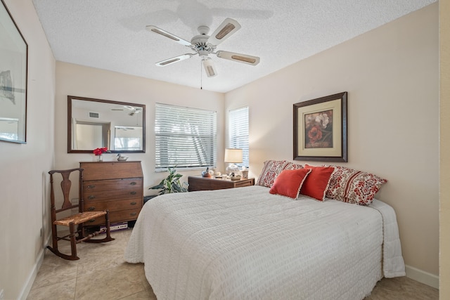 tiled bedroom featuring a textured ceiling and ceiling fan