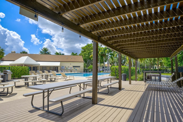 wooden terrace featuring a community pool and area for grilling