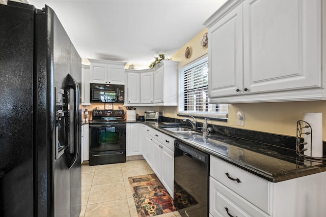 kitchen with dark stone countertops, light tile patterned floors, black appliances, sink, and white cabinets