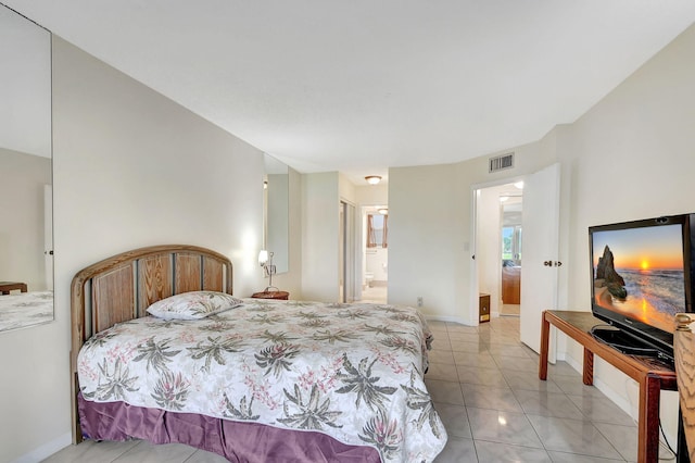 bedroom featuring light tile patterned floors, ensuite bath, visible vents, and baseboards