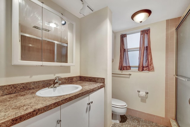 full bathroom with tile patterned flooring, toilet, vanity, baseboards, and a shower stall