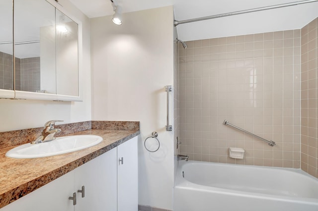 bathroom with tiled shower / bath and vanity