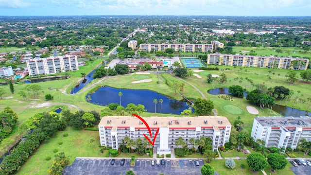 birds eye view of property featuring view of golf course, a water view, and a city view