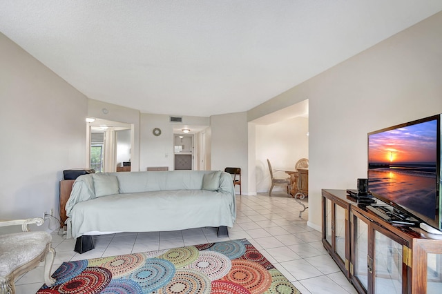 interior space featuring light tile patterned flooring, ensuite bath, visible vents, and baseboards