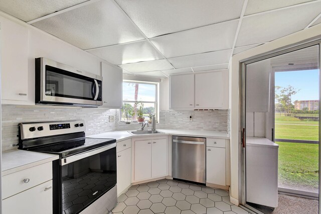 kitchen featuring tasteful backsplash, sink, stainless steel appliances, and white cabinets