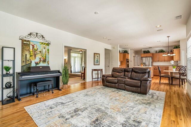 living room featuring light wood-type flooring and a chandelier