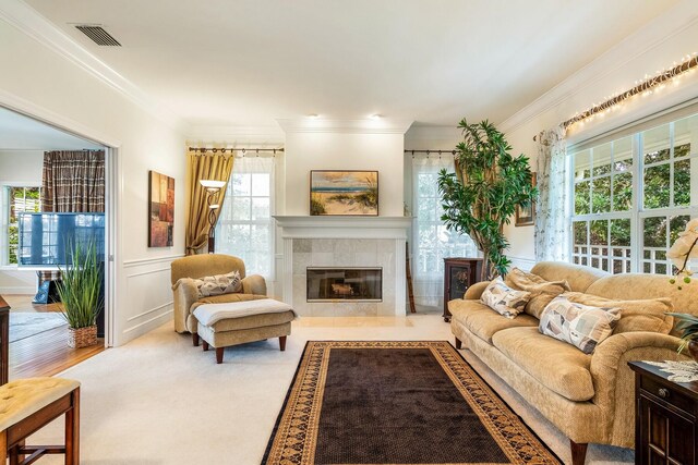 living room featuring a tiled fireplace and ornamental molding