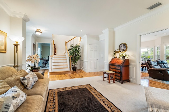 living room with crown molding and light hardwood / wood-style floors