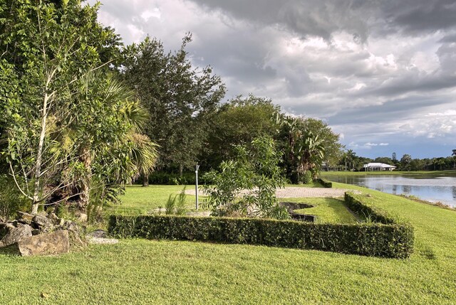 view of home's community featuring a water view and a yard