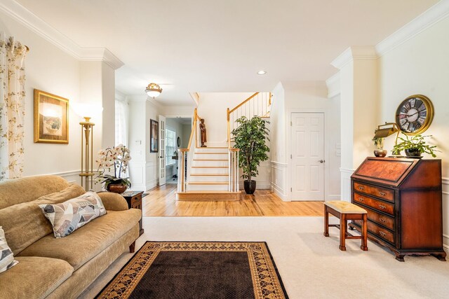 living room featuring crown molding and light hardwood / wood-style flooring