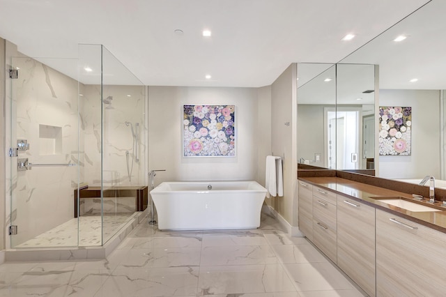 bathroom featuring a marble finish shower, marble finish floor, vanity, and a freestanding tub