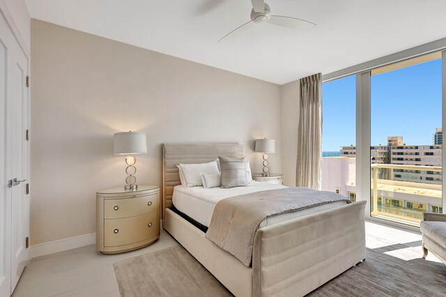 bedroom with ceiling fan and expansive windows