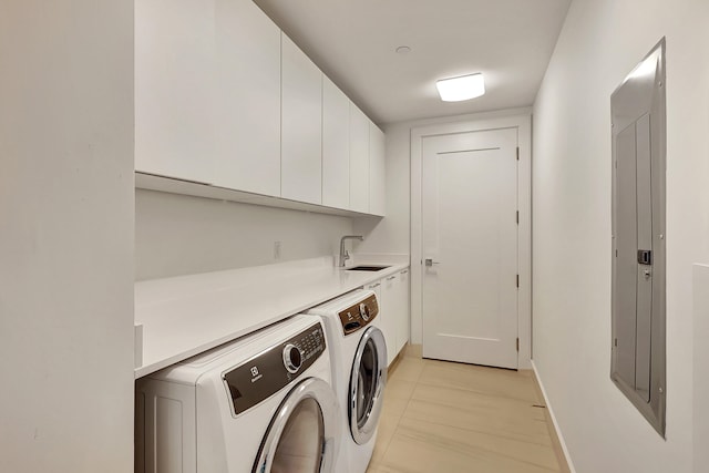 clothes washing area with sink, washing machine and clothes dryer, electric panel, cabinets, and light tile patterned floors